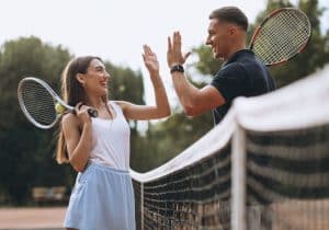 a young couple playing tennis socially
