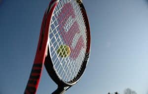 close up of tennis racquet hitting a tennis ball